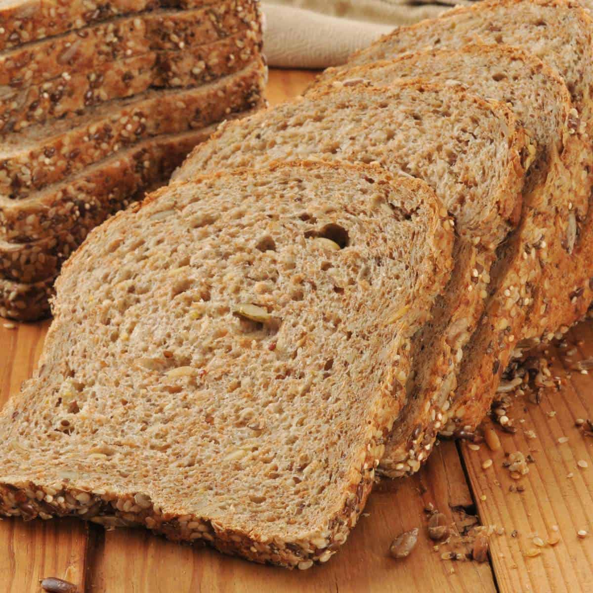 A loaf of bread with sesame seeds on a wooden table.