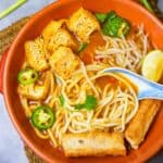 A bowl of tofu noodle soup with noodles and tofu.